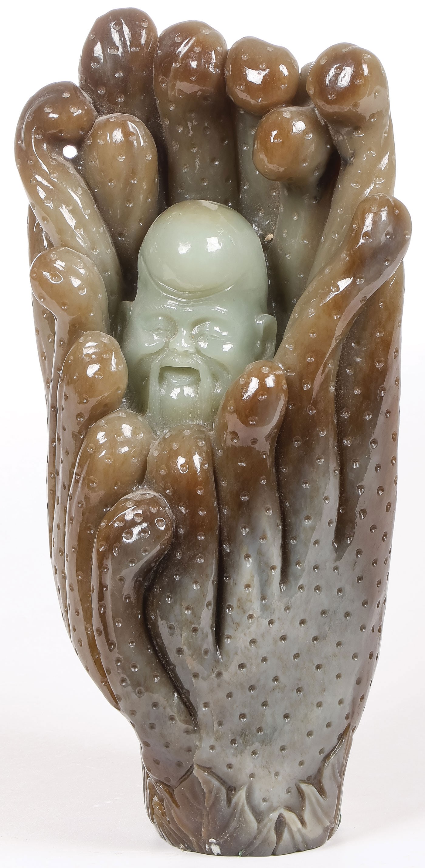 CHINESE CARVED JADE BUDDHA HAND: CHINESE CARVED JADE BUDDHA HAND. Finely and deeply carved in full round with stippled surface and the interior with an emerging Buddha head. Height 10 inches (25.4cm). SHIPPING NOTICE: If you are not