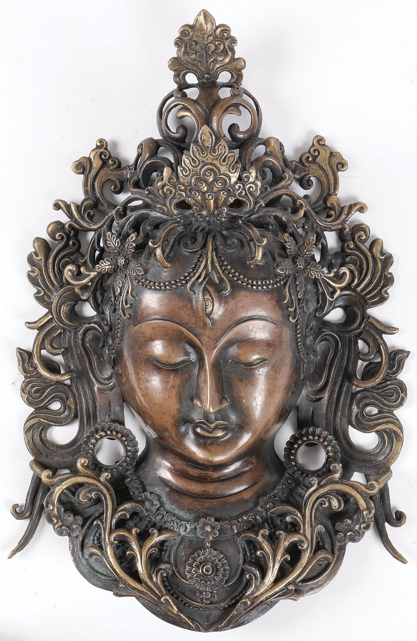 BRONZE BUDDHA HEAD PLAQUE: BRONZE BUDDHA HEAD PLAQUE. Comprising a very finely cast, pierced, and patinated bronze Buddha head, flat back, and designed for suspension. Height 12.25 inches (31cm). SHIPPING NOTICE: If you are