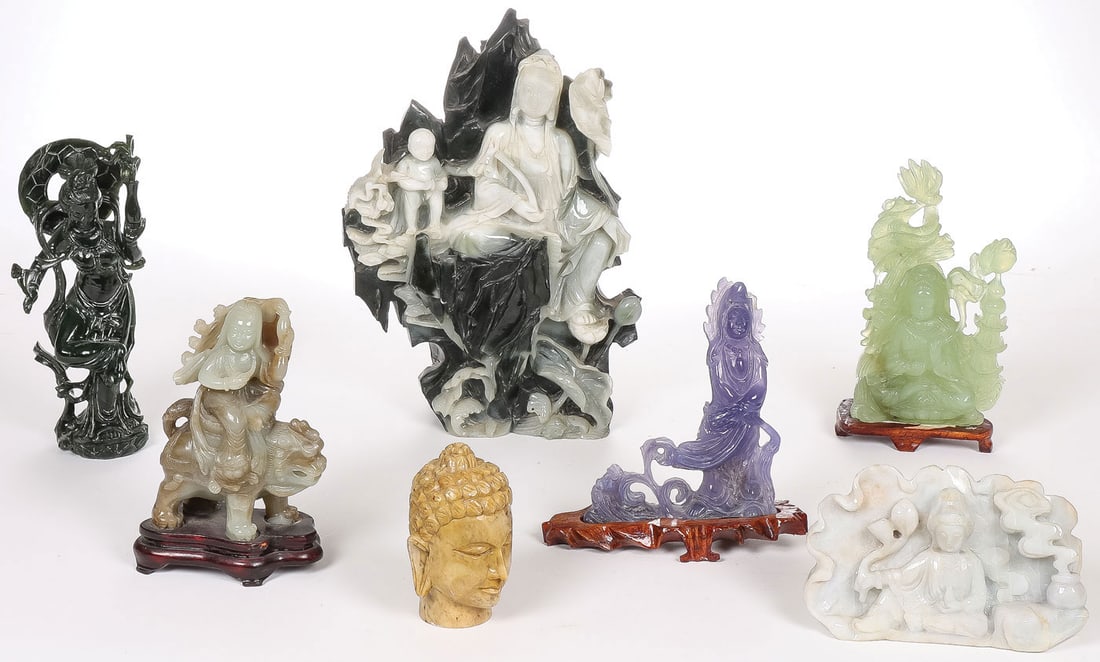 CHINESE BUDDHISTIC JADE & HARDSTONE GROUP: CHINESE BUDDHISTIC JADE & HARDSTONE GROUP. Comprising a good group of seven finely carved figures, including a large and impressive jade Guanyin seated in a mountainous landscape amongst lotus