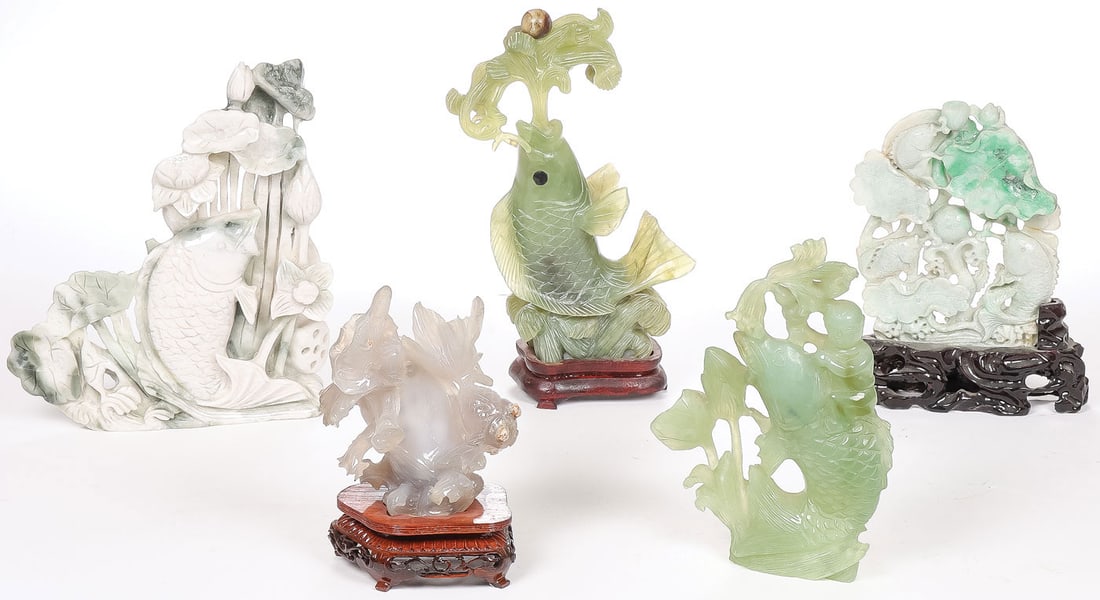 5 CHINESE CARVED JADE FIGURES: 5 CHINESE CARVED JADE FIGURES. Comprising a good group of Chinese carved jade, including a carved green jade fish spouting water and resting on a conforming wood stand, another fish amongst aquatic