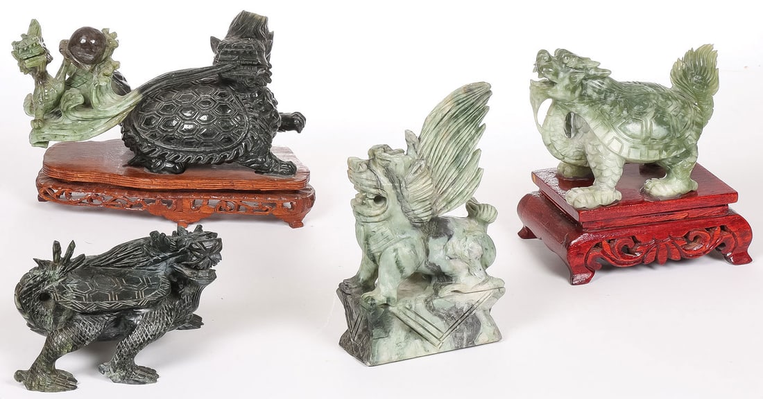 4 CHINESE CARVED HARDSTONE CREATURES: 4 CHINESE CARVED HARDSTONE CREATURES. Comprising four carved hardstone mythological creatures, including three Longgu?, two on conforming wood stands, and a foo lion. Greatest measurement 9.5 inches