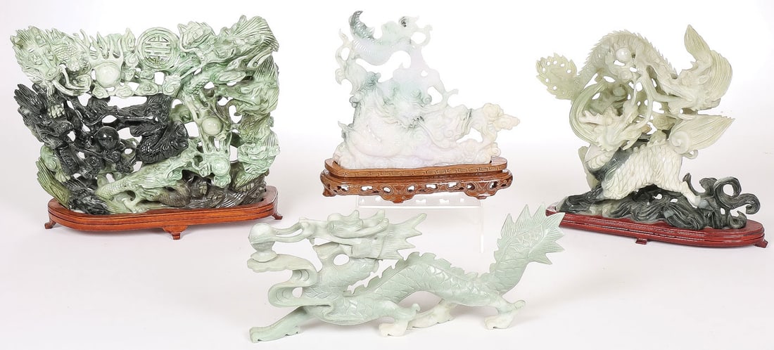 CHINESE CARVED JADE DRAGONS: CHINESE CARVED JADE DRAGONS. Comprising three carved jade dragon groupings, each on conforming wood stands, together with a carved hardstone prowling dragon. Greatest overall measurement 12 inches (30