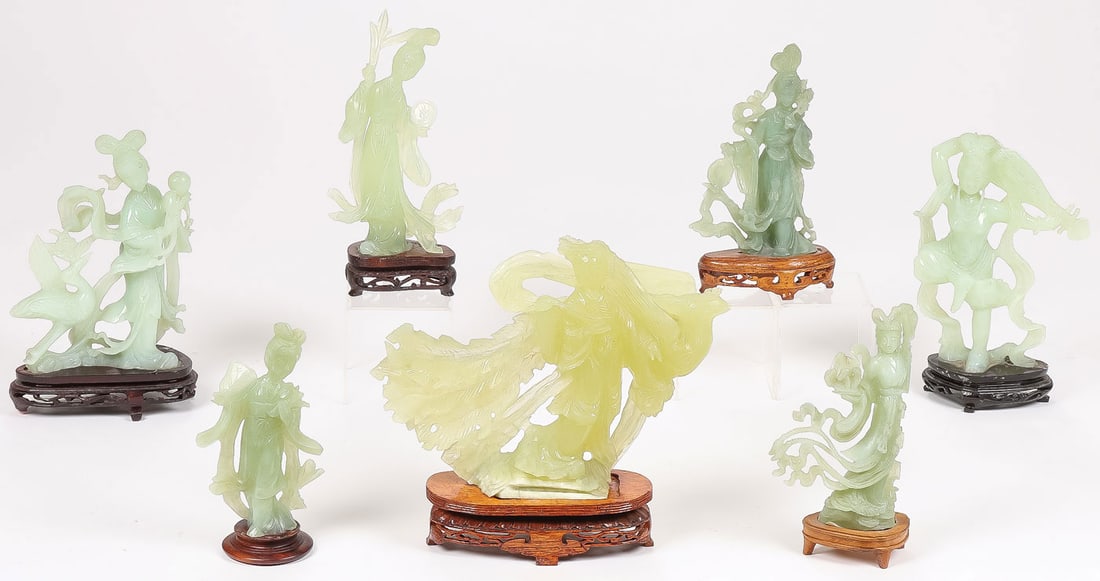 7 CHINESE CARVED JADE & HARDSTONE FIGURES: 7 CHINESE CARVED JADE & HARDSTONE FIGURES. Comprising seven finely carved figures of Guanyin or maidens, each carved in full round with flowing robes and resting on conforming wood stands, as shown.