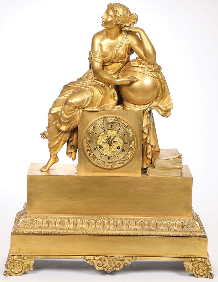 GILT BRONZE FRENCH EMPIRE MANTLE CLOCK: GILT BRONZE FRENCH EMPIRE MANTLE CLOCK. Finely sculpted with a figure of Urania, the Muse of Astronomy, resting on a square pedestal atop a stepped rectangular base. The dial surrounded with zodiac sy