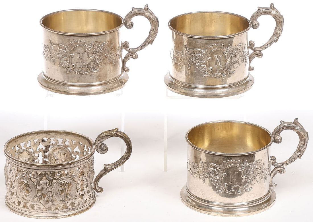 3 SILVER TEA GLASS HOLDERS: 3 SILVER TEA GLASS HOLDERS. Comprising three German .800 silver tea glass holders, with scroll handles and rocaille scroll cartouche, each engraved with the letter N, height 2.75 inches (7cm). Total