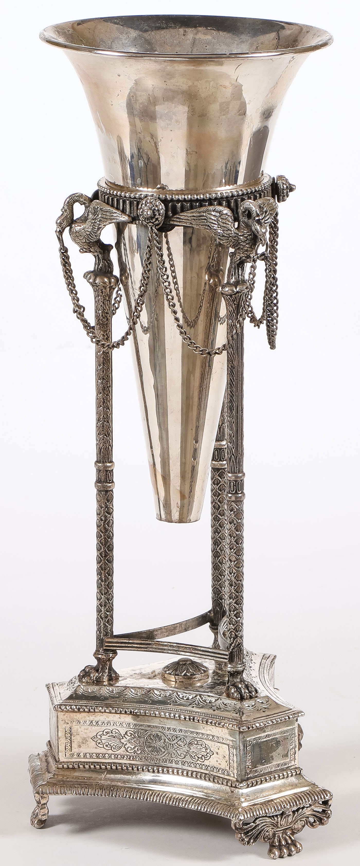 ORNATE SILVER-PLATED VASE STAND, C. 1880: ORNATE SILVER-PLATED VASE STAND, C. 1880. Raised on paw feet, the triangular base with squared corners, heavily engraved, and supporting three legs terminating with swan heads clutching chains, and wi