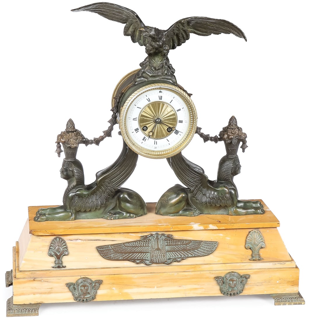 FRENCH EGYPTIAN MOTIF MANTLE CLOCK: FRENCH EGYPTIAN MOTIF MANTLE CLOCK. The rectangular footed tapered base in Sienese marble mounted with brass Egyptian-style plaques, upon which rests two recumbent sphinx figures with extended wings