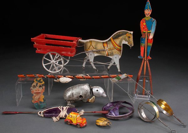 AN 11 PIECE PENNY TOY GROUP, EARLY 20TH CENTURY.: AN 11 PIECE PENNY TOY GROUP, EARLY 20TH CENTURY. Comprising a wood and paper litho horse and cart pull toy, an animated jester squeeze toy, a chasing mice tin litho toy, three tin whirligigs, a tin li
