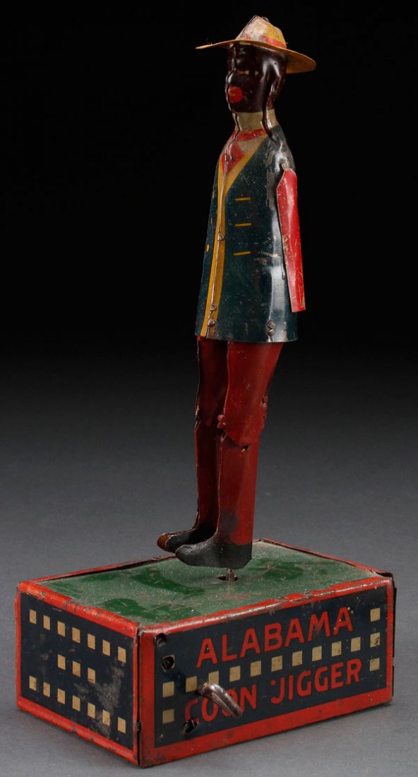 A BLACK AMERICANA "TOMBO THE ALABAMA COON JIGGER" TOY: A BLACK AMERICANA "TOMBO- THE ALABAMA COON JIGGER", CIRCA 1910. Strauss key wind tin litho dancer. Height 10.25 inches (26 cm).