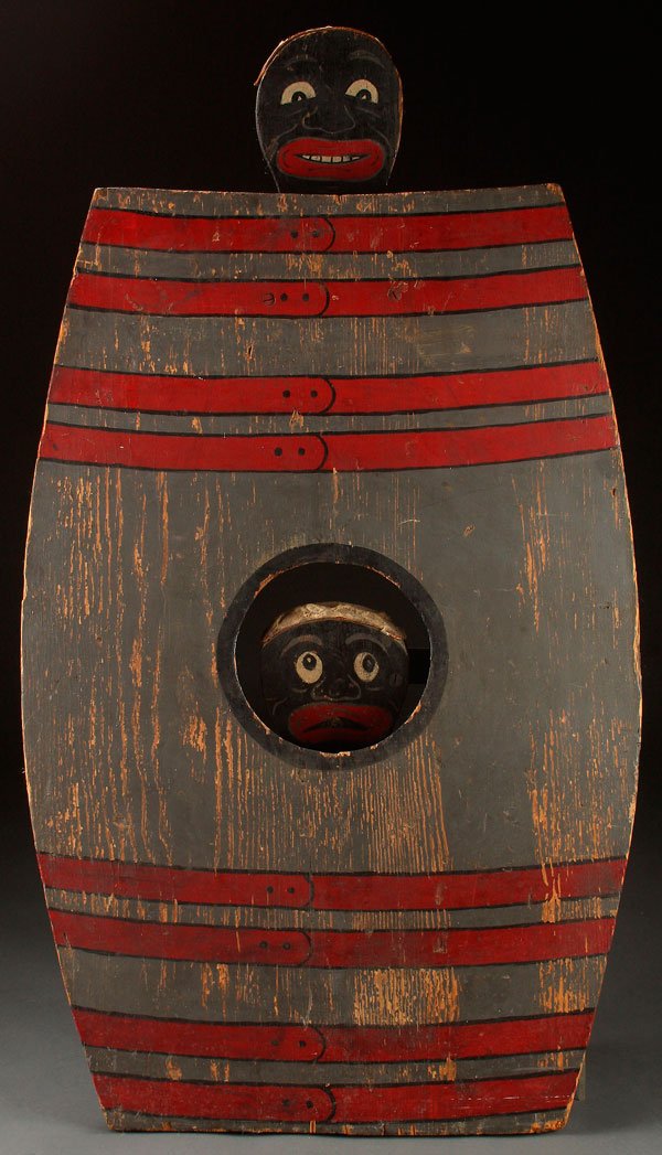 A LARGE BLACK AMERICANA CARNIVAL BEAN TOSS GAME,: A LARGE BLACK AMERICANA CARNIVAL BEAN TOSS GAME, EARLY TO MID 20TH CENTURY. Polychrome wood in the form of a large sugar barrel with two black face targets. Height 42 inches (107 cm).