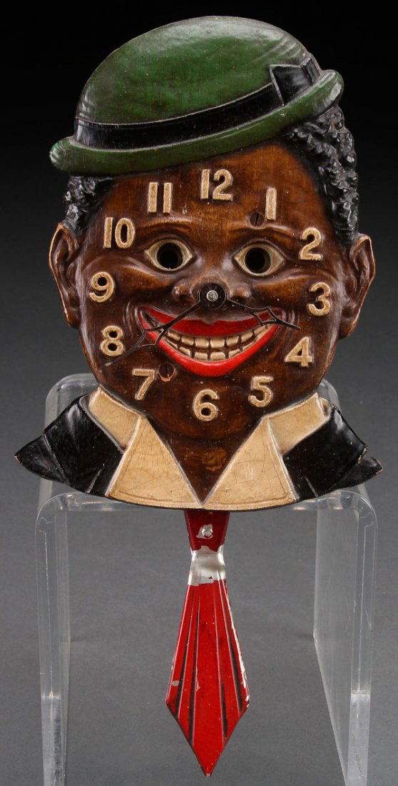 A BLACK AMERICANA LUX "DIXIE BOY" NOVELTY WALL CLOCK: A BLACK AMERICANA LUX "DIXIE BOY" NOVELTY WALL CLOCK, CIRCA 1930S. Length 9 inches (23 cm).