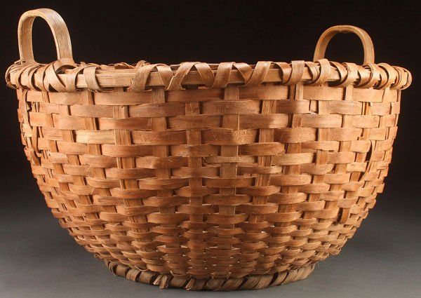 A LARGE PRIMITIVE COUNTRY MENDING OR SEWING BASKET: A LARGE PRIMITIVE COUNTRY MENDING OR SEWING BASKET, CIRCA 1900. With bow handles and a demi-john bottom. Diameter 24 inches (61 cm).