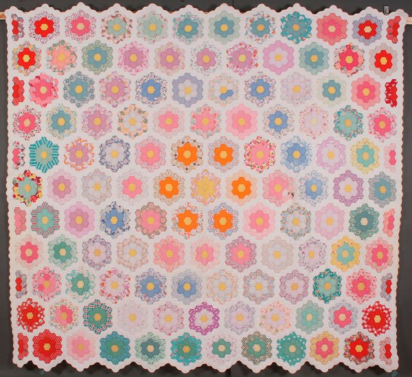 A HAND STITCHED AND PIECED QUILT: A HAND STITCHED AND PIECED QUILT, EARLY 20TH CENTURY. In a Dresden plate pattern, 88 inches x 81 inches (224 x 206 cm). Together with a double wedding ring tied comforter, 86 inches x 71 inches (218 x