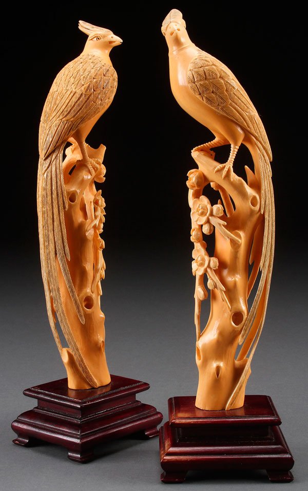 A LARGE PAIR OF CHINESE CARVED IVORY ASIATIC PHEASANTS: A LARGE PAIR OF CHINESE CARVED IVORY ASIATIC PHEASANTS, 20TH CENTURY. Each depicted in opposing form atop tree trunks with lotus blossoms and raised on wooden plinths. The ivory height 11 inches (28 c