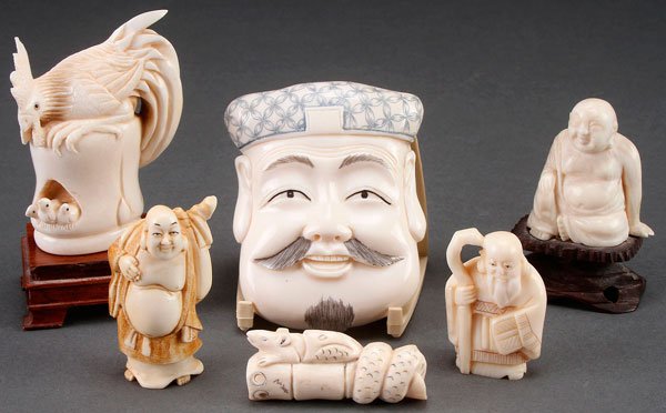 JAPANESE CARVED IVORY NETSUKES AND BUDDHAS: A SIX PIECE GROUP OF JAPANESE CARVED IVORY, EARLY TO MID 20TH CENTURY. Comprising a facial mask ornament, a cockerel and chicks netsuke, a snake swallowing rat netsuke, an immortal with staff, and two