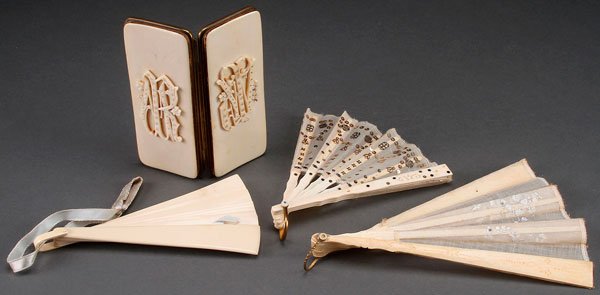 A CONTINENTAL CARVED IVORY GROUP: A CONTINENTAL CARVED IVORY GROUP, CIRCA 1900. Comprising a very fine hinged spectacle case with carved monogram and two folding fans with ivory sticks; together with a faux ivory or celluloid fan. The