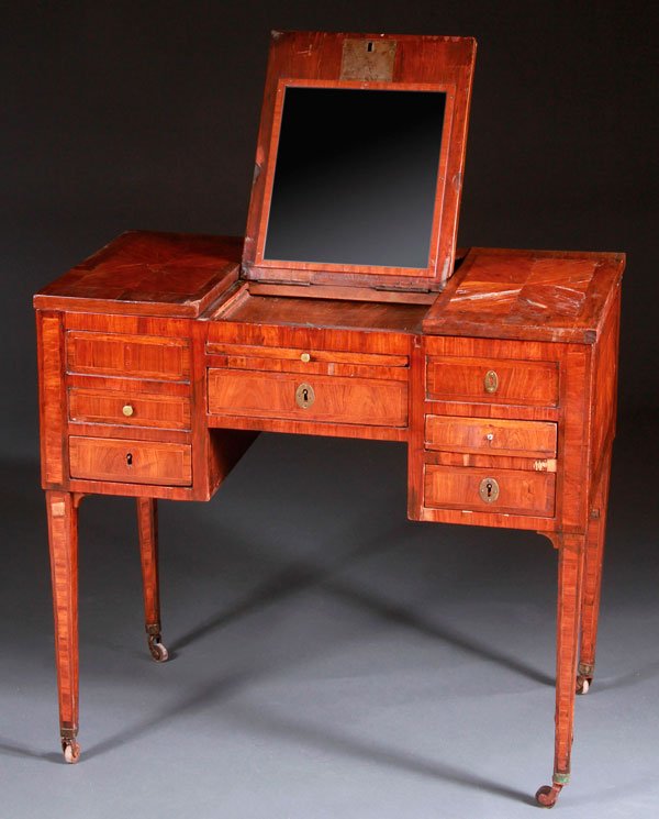 AN ENGLISH REGENCY INLAID MAHOGANY "BEAU BRUMMEL": AN ENGLISH REGENCY INLAID MAHOGANY "BEAU BRUMMEL" DRESSING VANITY, EARLY 19TH CENTURY. With hinged lid containing a glazed mirror, five drawers and a pull-out tablet, raised on inlaid tapering legs, i