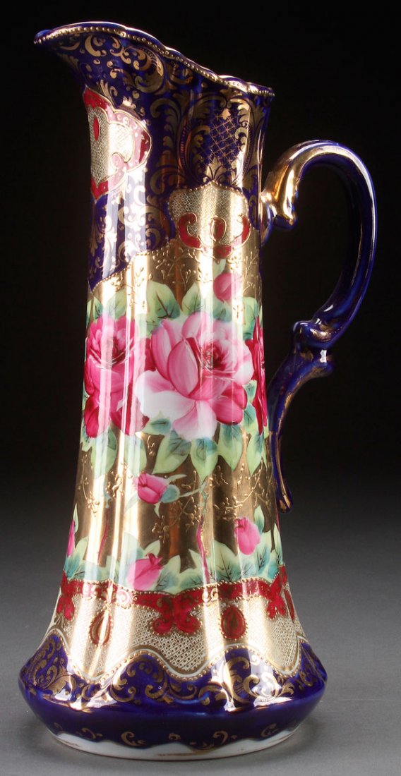 HAND PAINTED NIPPON PORCELAIN TANKARD, CIRCA 1900.: HAND PAINTED NIPPON TANKAR, CIRCA 1900. With large open roses decoration on cobalt blue ground with gilt scrolling. Unmarked. Height 15.75 inches (40 cm).