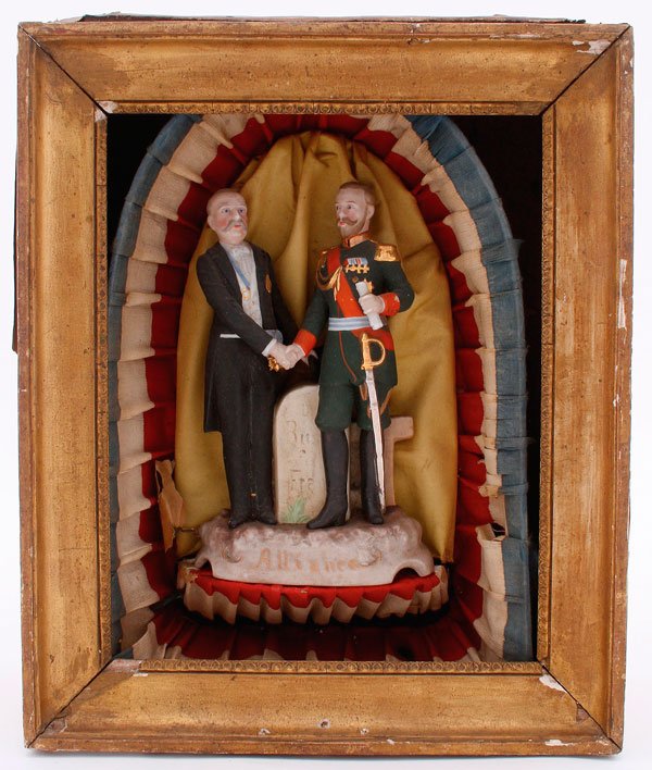 FRANCO/RUSSIAN GLAZED FIGURINE: A GLAZED BISQUE FIGURE OF TSAR NICHOLAS II AND PRESIDENT FELIX FAURE OF FRANCE SHAKING HANDS, END OF 19TH CENTURY. Between them a plaque inscribed in Russian Russia and France and below, the word Alli