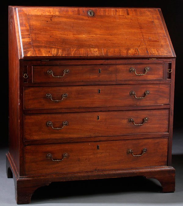 A GEORGE III SLANT FRONT MAHOGANY DESK, CIRCA 1800: A GEORGE III SLANT FRONT MAHOGANY DESK, CIRCA 1800. With four drawers below a slant front opening to reveal pigeon hole compartments and fitted stationary forms with inlaid line work. Height 39.75 inc