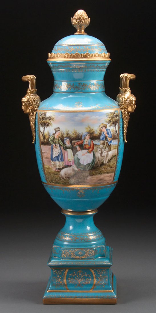 A LARGE IMPRESSIVE DRESDEN STYLE PORCELAIN URN: A LARGE AND IMPRESSIVE DRESDEN STYLE PORCELAIN HAND PAINTED LIDDED URN, 20TH CENTURY. With romantic scenes on obverse and reverse flanking gilt porcelain facial mask handles. Spurious underglaze Richa
