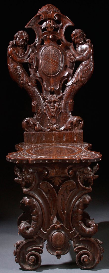 ITALIAN RENAISSANCE REVIVAL CARVED OAK HALL SEAT: A NORTHERN ITALIAN RENAISSANCE REVIVAL CARVED OAK HALL SEAT, LATE 19TH CENTURY. The reticulated back with figural mermaids supporting a scrolled cartouche above a relief carved seat raised on figural 