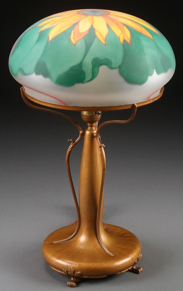 A PAIRPOINT REVERSE PAINTED GLASS TABLE LAMP: A PAIRPOINT REVERSE PAINTED GLASS TABLE LAMP, EARLY 20TH CENTURY. With stylized sunflower decorated satin glass shade on a gold patinated base. The shade signed The Pairpoint Corp., base stamped Pairp