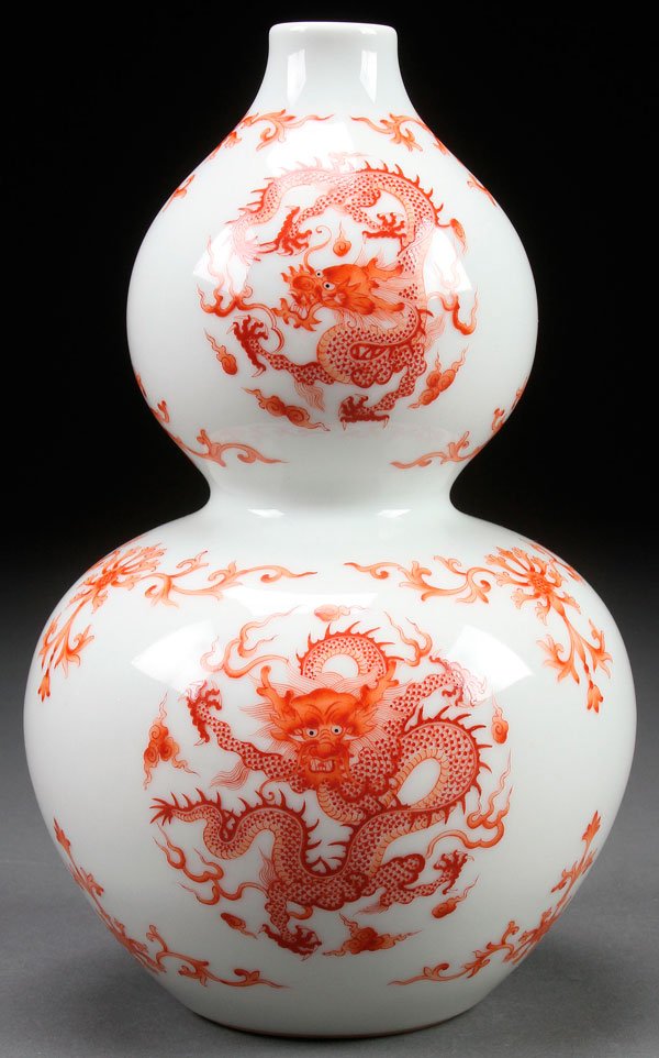 A CHINESE RED OXIDE "DRAGONS" PORCELAIN VASE: A CHINESE RED OXIDE "DRAGONS" PORCELAIN DOUBLE GOURD VASE. Decorated with five clawed dragon medallions and scrolled foliates. Base with Guangxu mark. Height 9 inches (23 cm).