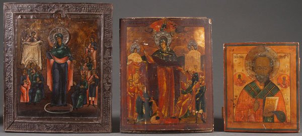 A GROUP OF THREE RUSSIAN ICONS. Comprising a larg: A GROUP OF THREE RUSSIAN ICONS. Comprising a large icon of the Mother of God Joy to All Who Sorrow, the borders overlaid with tin repoussé basma and the head of the Virgin surrounded by an applied me