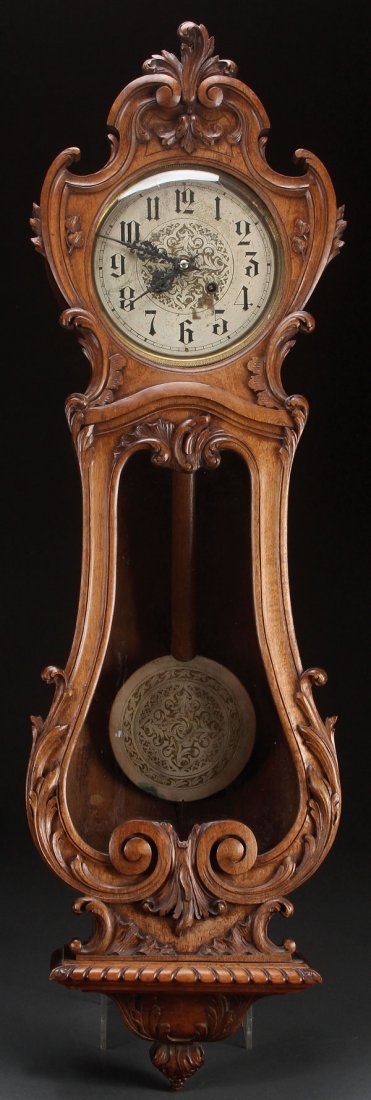 A VIENNA STYLE CARVED WALNUT REGULATOR CLOCK: A VIENNA STYLE CARVED WALNUT WALL REGULATOR, LATE 19TH CENTURY. With carved acanthus scrolled decoration. Height 42 inches (106.5 cm).