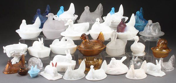 32 MILK GLASS COVERED ANIMAL DISHES: A LARGE MILK GLASS CANDY DISH GROUP, EARLY 20TH CENTURY. 32 pieces consisting of hens on nest, covered hens, rabbit lid, figural swans, along with some clear glass figural candy dishes, some incomplet