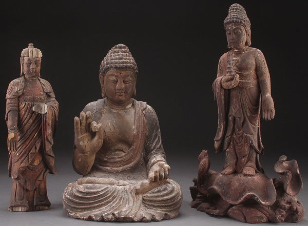THREE CARVED WOOD BUDDHIST FIGURES, 20TH CENTURY,: THREE CARVED WOOD BUDDHIST FIGURES, 20TH CENTURY, PERHAPS EARLIER. Comprising a standing Buddha with gilt and polychrome remnants, a large seated Buddha with polychrome, and a standing carved and poly