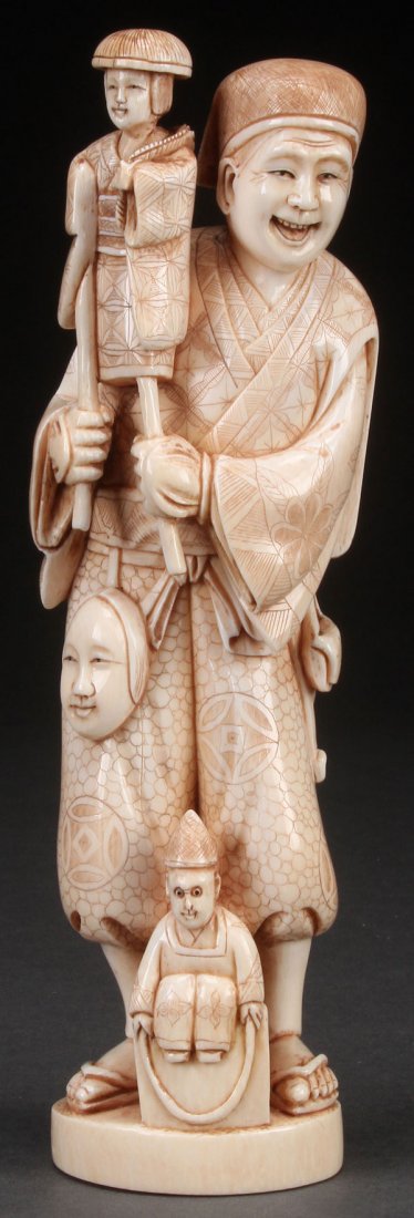 A FINE JAPANESE CARVED IVORY OKIMONO,: A FINE JAPANESE CARVED IVORY OKIMONO, PROBABLY MEIJI PERIOD. Depicting a street entertainer with puppet, incised chop on base. Height 8.5 inches (21.6 cm).