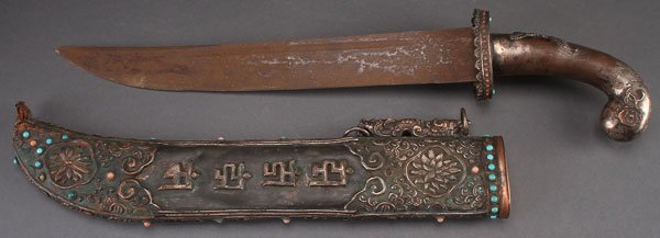 A CHINESE MONGOLIAN STYLE SILVERED COPPER DAGGER,: A CHINESE MONGOLIAN STYLE SILVERED COPPER DAGGER, 20TH CENTURY. With embossed decoration and inscription, set with turquoise and coral jewels. Total length 21.5 inches (54.6 cm).