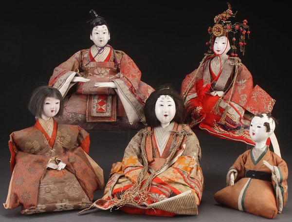FIVE JAPANESE NINGYO DOLLS, MEIJI PERIOD: A GROUP OF FIVE JAPANESE NINGYO DOLLS, MEIJI PERIOD. Each with gofun faces and inset glass eyes, dressed in woven silk garments. Largest height 10 inches (20.5 cm).