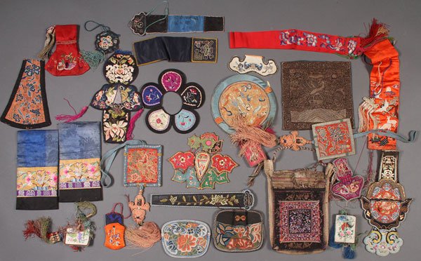 A CHINESE AND KOREAN EMBROIDERED TEXTILE GROUP: A CHINESE AND KOREAN EMBROIDERED TEXTILE GROUP, 19TH/20TH CENTURY. 29 pieces including pouches, fan cases, tassled mirrors, and collared pieces. Some with Buddhist symbols. Largest length approximatel