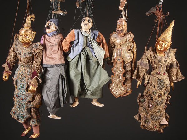 A GROUP OF FIVE BURMESE MARIONETTES: A GROUP OF FIVE BURMESE MARIONETTES, 20TH CENTURY. Each in carved wood and gesso with painted features and elaborate stitched gowns with sequined beading and jewelry. Largest length approximately 34 i
