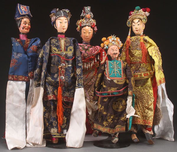 F FIVE CHINESE THEATRICAL COSTUME PUPPETS: A GROUP OF FIVE CHINESE THEATRICAL COSTUME PUPPETS, 20TH CENTURY. With jointed wood bodies and polychrome features, each dressed in elaborate court style garments. Largest length 22 inches (56 cm).