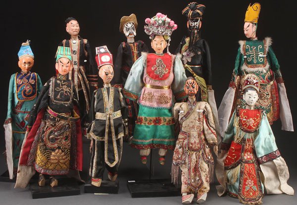 A GROUP OF 10 CHINESE THEATRICAL COSTUME PUPPETS,: A GROUP OF 10 CHINESE THEATRICAL COSTUME PUPPETS, 20TH CENTURY. Jointed wood with polychrome features, each dressed in elaborately embroidered court robes with silver and gilt threading. Largest lengt