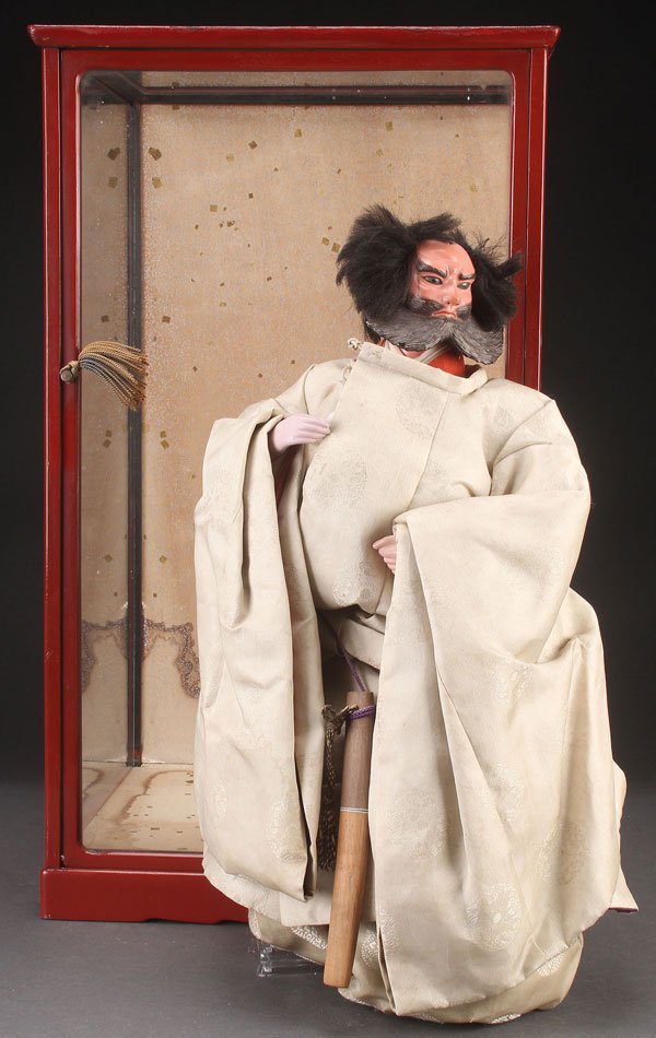 A JAPANESE NINGYO DOLL SUGAWARA NO MICHIZANE: A JAPANESE NINGYO DOLL, MEIJI PERIOD. Probably depicting Sugawara No Michizane, with gofun head and beard, inset eyes, and applied mohair, dressed in period type clothing. Accompanied by a glass displ