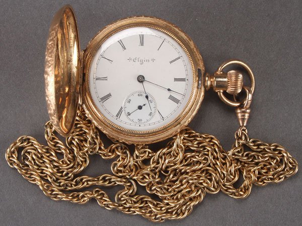 AN ELGIN GOLD FILLED HUNTING CASE POCKET WATCH: AN ELGIN GOLD FILLED HUNTING CASE POCKET WATCH, CIRCA 1900. With engraved and two tone inlaid floral gold case. Serial number 4672XXX. Diameter 1.625 inches. With gold filled chain.