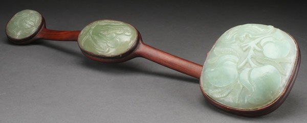 CHINESE CARVED HARDSTONE AND ROSEWOOD SCEPTER: A CHINESE CARVED HARDSTONE AND ROSEWOOD RUYI FORM SCEPTER, 20TH CENTURY. Mounted with carved hardstone medallions depicting bats, peaches and a Buddha's hand. Length 21.25 inches (54 cm).