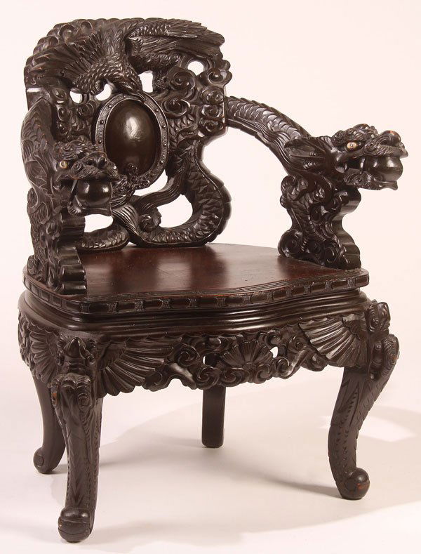 A CHINESE EXPORT CARVED FIGURAL DRAGON ARMCHAIR: A CHINESE EXPORT CARVED FIGURAL DRAGON ARMCHAIR, CIRCA 1900. With carved eagle and dragon's tail backrest design flanked by figural dragon armrests raised on carved figural dragon form legs. Height 34