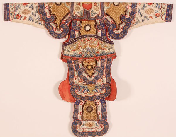 KOREAN CHILD'S EMBROIDERED FESTIVAL JACKET: A KOREAN CHILD'S EMBROIDERED FESTIVAL JACKET, 20TH CENTURY. Fully embroidered in multi-colored silk and gold threads, with dragons and Buddhist motifs, further embellished with mirrored tiles. Width 4