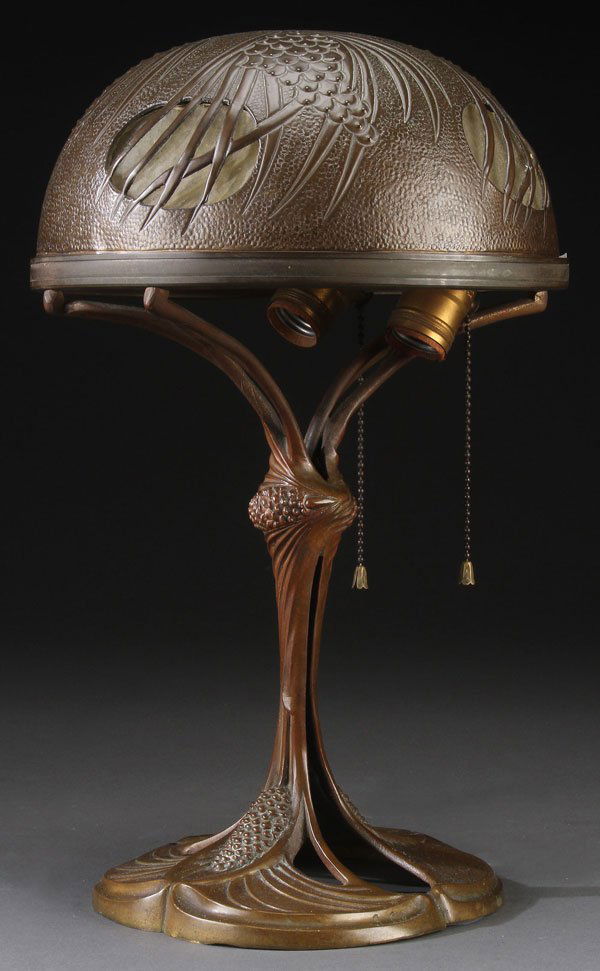 GEORGES LELEU ART NOUVEAU TABLE LAMP, EARLY 20TH C.: ART NOUVEAU BRONZE TABLE LAMP, Georges Leleu (French 1883-1961). The pierced shade with embossed pine cone design containing four frosted glass panels, raised on a stylized pine cone and needle bronze