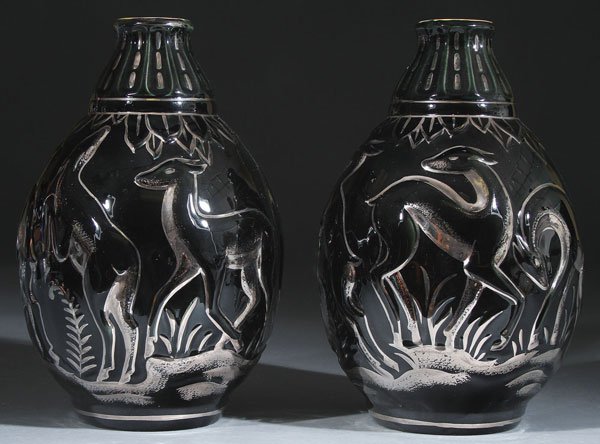 A PAIR OF BOCH FRERES ART DECO "DEER" VASES: A PAIR OF BOCH FRERES ART DECO "DEER" MATCHING CERAMIC VASES, EARLY 20TH CENTURY. Each with stylized and embossed deer on a mirror black ground with silvered accents, the interior in mottled orange an