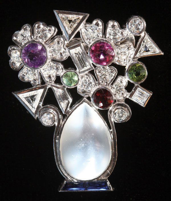 PLATINUM, DIAMONDS AND GEMSET GIARDINETTO BROOCH: A PLATINUM, DIAMONDS AND GEMSET GIARDINETTO BROOCH, LAST HALF 20TH CENTURY. In floral form, modeled as an oval moonstone shaped vase, set with 21 diamonds of trillion, round, brilliant and baguette sh