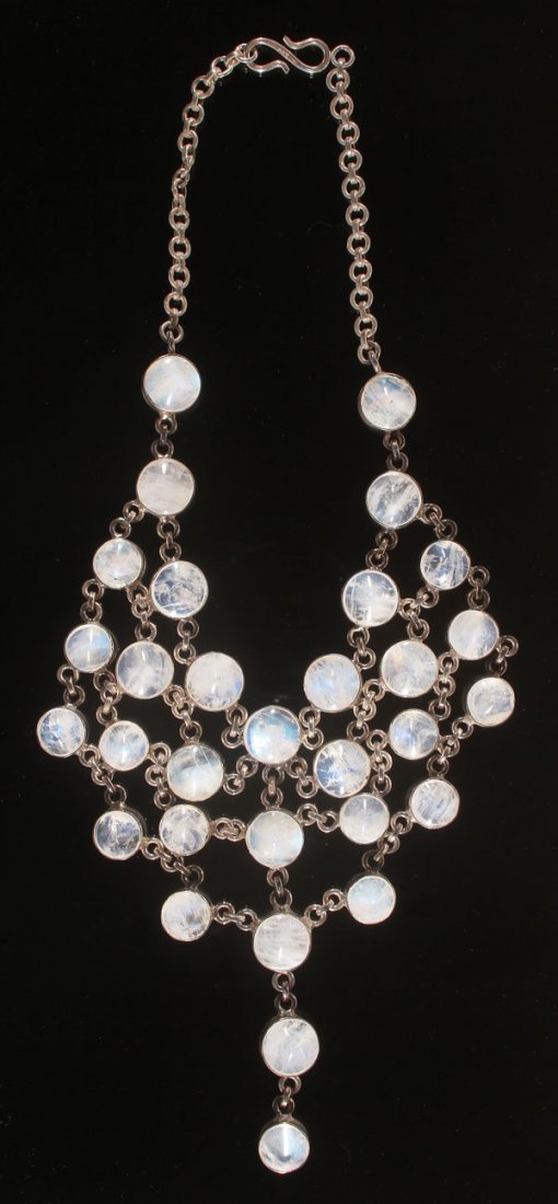 ARTS & CRAFTS STYLE MOONSTONE & SILVER NECKLACE: AN ARTS AND CRAFTS STYLE MOONSTONE AND SILVER NECKLACE, 20TH CENTURY. A scintillating bib necklace formed of 31 sugarloaf cabochon moonstones, bezel set with chain link connectors. Length 16.5 inches 