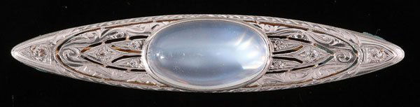 BELLE EPOQUE MOONSTONE & DIAMOND BROOCH: A VERY FINE BELLE EPOQUE MOONSTONE AND DIAMOND BROOCH, BY MARCUS AND CO., CIRCA 1900. Of elongated oval form, the oval cabochon moonstone approximately 18 mm x 15 mm set within an engraved open foliat