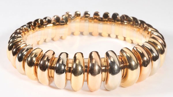 A BVLGARI TRI-TONE 18K GOLD SPRING BRACELET: A BVLGARI TRI-TONE 18K GOLD SPRING BRACELET, LATE 20TH CENTURY. With diminishing concentric ribs in white, yellow and pink gold, length 2.75 inches (7cm), interior width 2.25 inches (5.7cm), weight 3.